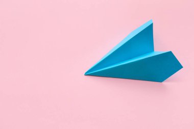 Blue paper plane on pink background