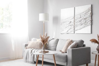 Kanepe, masa ve 3 boyutlu tekstil sanatıyla modern oturma odasının içinde.