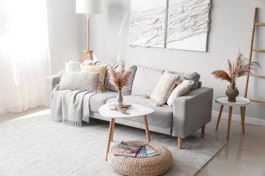 Kanepe, masa ve 3 boyutlu tekstil sanatıyla modern oturma odasının içinde.