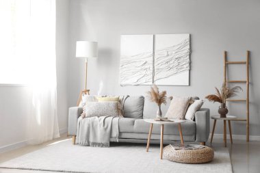 Kanepe, masa ve 3 boyutlu tekstil sanatıyla modern oturma odasının içinde.