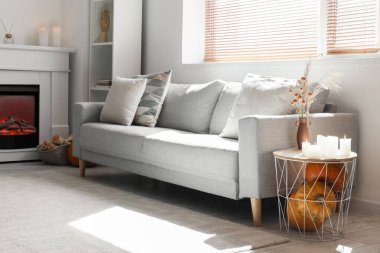 Gri kanepesi, masası ve şöminesi olan oturma odası.