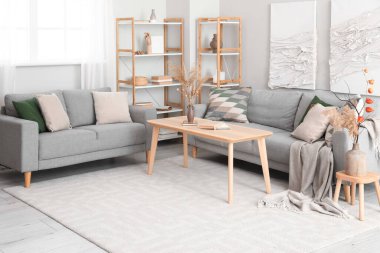 Kanepeleri, masası ve 3 boyutlu tekstil tablosu olan modern oturma odası.