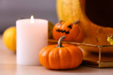 Cadılar Bayramı balkabakları ve yanan mumlar masada, yakın plan.