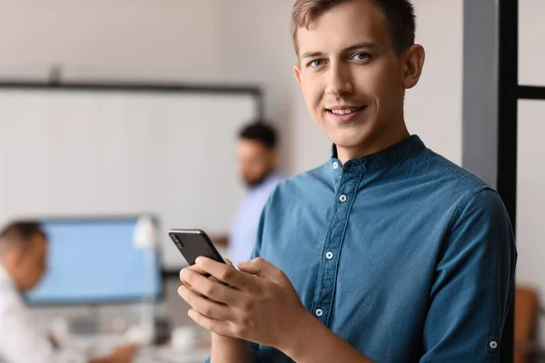 Young bank manager working with mobile phone in office