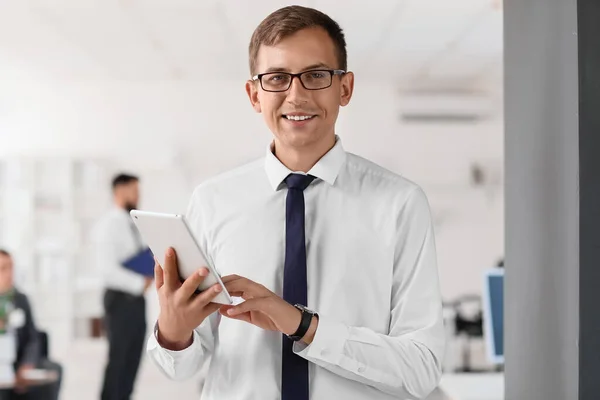 Young bank manager working with tablet computer in office