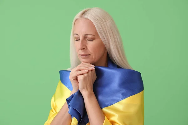 Mature Woman Flag Ukraine Praying Green Background — Stock Photo, Image
