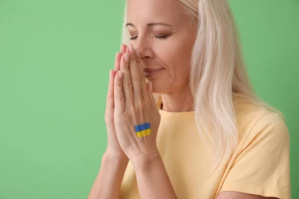 Mature Woman Drawn Flag Ukraine Praying Green Background Closeup — Stock Photo, Image
