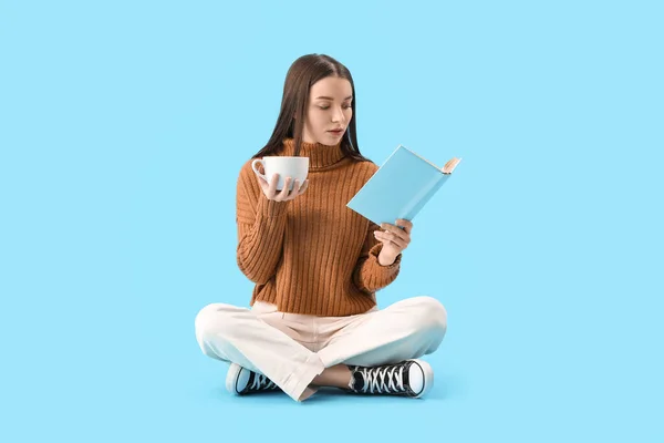 Jonge Vrouw Bruine Trui Met Kopje Cacao Leesboek Blauwe Achtergrond — Stockfoto