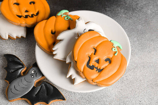Plate with Halloween cookies on black and white background