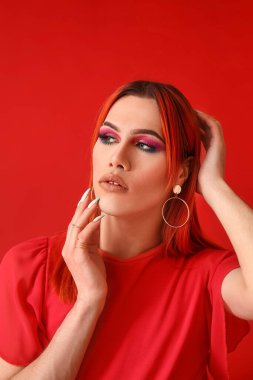 Kırmızı arka planda şık transseksüel kadın