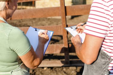 Çiftlikteki otlağın yanında yetişkin işçiler.