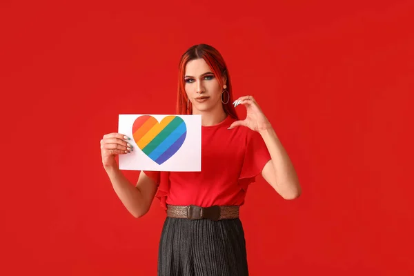 Stylowa Transseksualistka Trzymająca Kartkę Papieru Tęczowym Sercem Czerwonym Tle — Zdjęcie stockowe