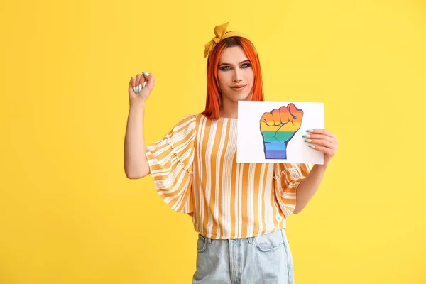 Stylowa Transseksualistka Trzymająca Kartkę Papieru Zaciśniętą Tęczową Pięścią Żółtym Tle — Zdjęcie stockowe