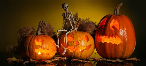 Carved Halloween pumpkins with skeleton on dark background