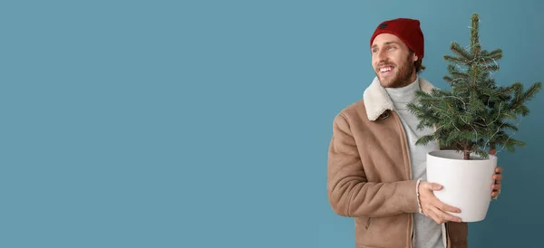 Snygg Ung Man Vinter Kläder Håller Julgran Blå Bakgrund Med — Stockfoto