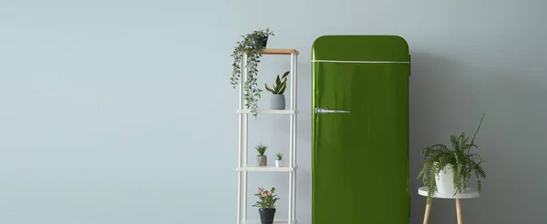 ライトウォールの近くに観葉植物とスタイリッシュなレトロな冷蔵庫 棚ユニットとテーブル デザインのバナー — ストック写真