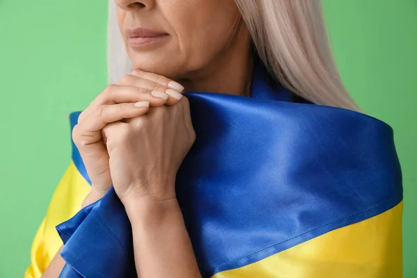 Dojrzała Kobieta Flagą Ukrainy Modli Się Zielonym Tle Zbliżenie — Zdjęcie stockowe