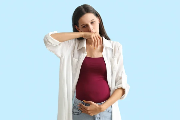 若いです妊娠中の女性とともに鼻血で青背景 — ストック写真