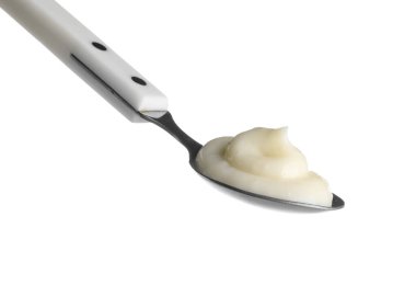 Beyaz arka planda bir kaşık lezzetli vanilyalı puding, yakın plan.