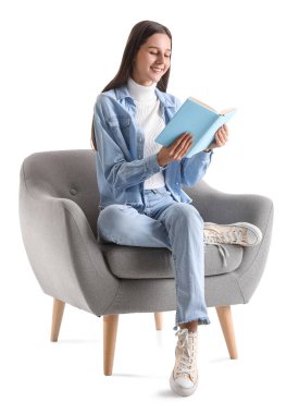 Beyaz arka planda yumuşak koltukta kitap okuyan güzel bir kadın.