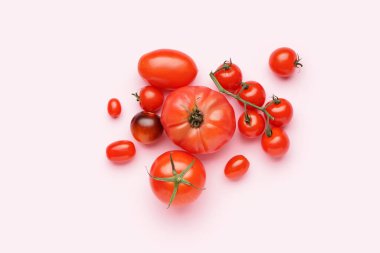 Pembe arka planda bir yığın olgun domates.