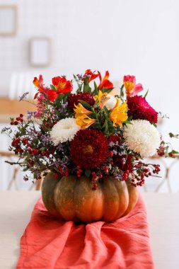 Mutfaktaki yemek masasında sonbahar çiçekli balkabağı, yakın plan.