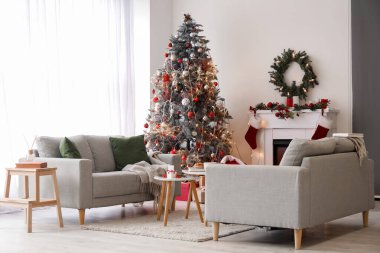 Koltukları ve Noel ağacı olan oturma odasının içi.