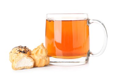 Beyaz arka planda bir fincan çay ve lezzetli ekler.