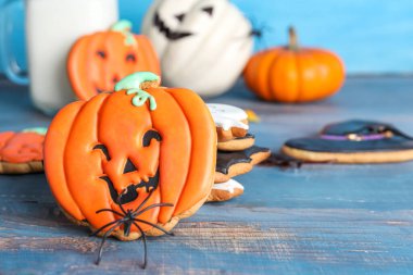 Mavi duvarın yanındaki masada örümcekli leziz Cadılar Bayramı kurabiyeleri, yakın plan.