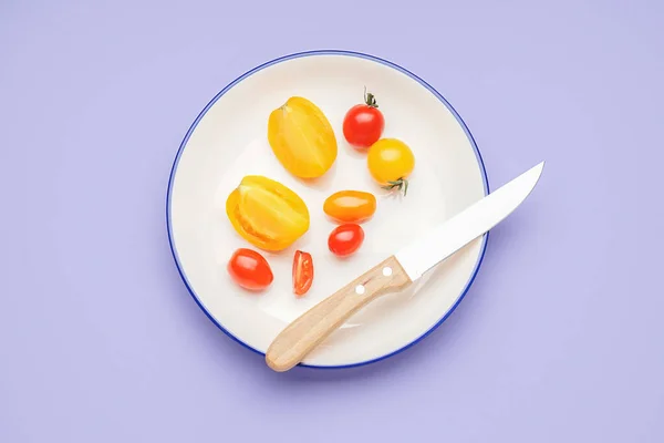 Plate with fresh tomatoes on color background