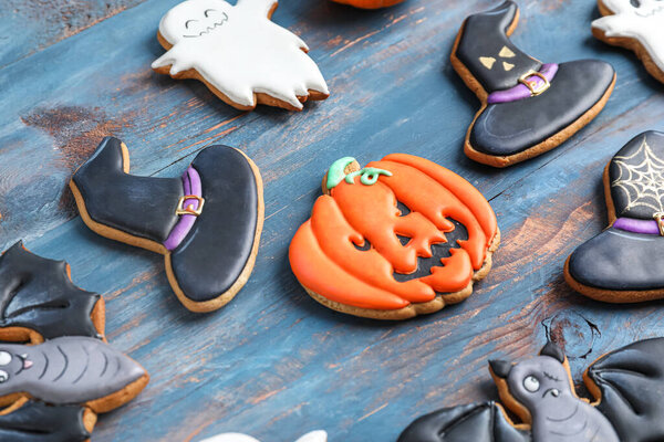 Tasty Halloween cookies on blue wooden background, closeup