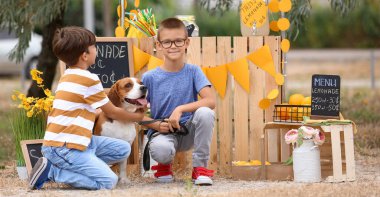 Parktaki limonata standının yanında köpekli şirin çocuklar.