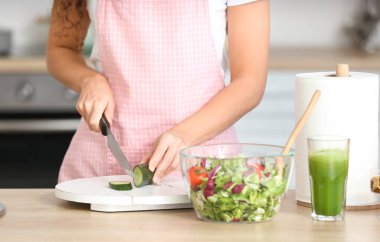 Genç kadın mutfakta taze salata yapıyor
