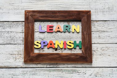 Metin İSPANISH Öğren ve beyaz ahşap arkaplanda çerçeve