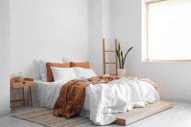 Büyük yataklı, merdivenli ve çiçekli bir aydınlatma odası.