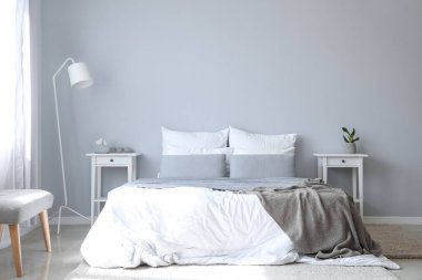 Büyük yataklı, masalı ve lambalı modern bir oda.