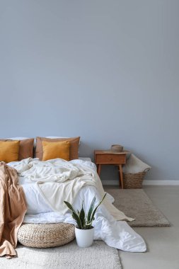 Büyük yatağı, masası ve pouf 'u olan modern oda.