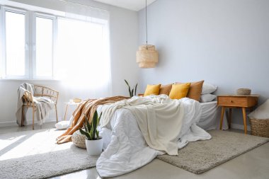 Büyük yataklı, masalı ve koltuklu modern bir oda.