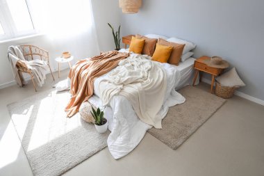 Büyük yataklı, masalı ve koltuklu modern bir oda.