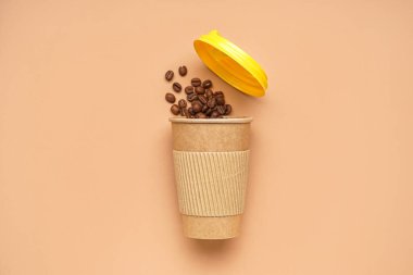 Arka planda kahve çekirdekleri olan kağıt bardak.