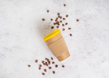 Kağıt bardak ve açık arkaplanda kahve çekirdeği.