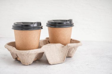 Açık arkaplanda kağıt bardakları olan tutucu