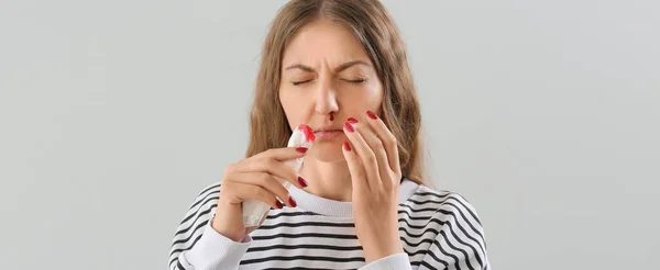 Mujer Joven Con Hemorragia Nasal Tejido Sobre Fondo Claro — Foto de Stock