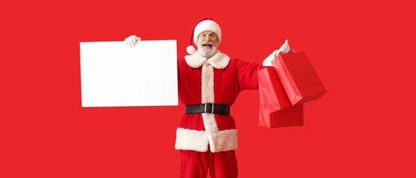 Szczęśliwy Święty Mikołaj Pustym Plakatem Torbami Zakupy Czerwonym Tle — Zdjęcie stockowe