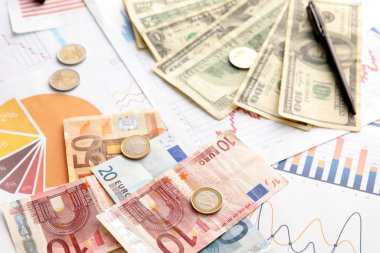 Diyagramlarda bozuk paraların olduğu farklı banknotlar, yakın plan. Değişim oranı kavramı