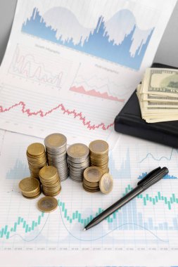 Gri duvarın yakınındaki diyagramlarda para ve kalem yığınları, yakın plan. Değişim oranı kavramı