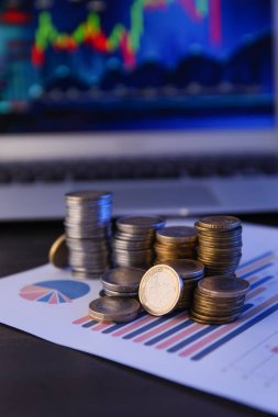 Ofisteki diyagramlarda yığınla bozuk para, yakın plan. Değişim oranı kavramı