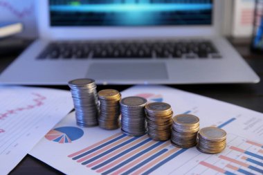 Ofisteki diyagramlarda yığınla bozuk para, yakın plan. Değişim oranı kavramı