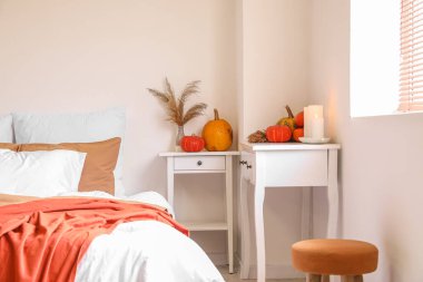 Vazolu masalar, otlar, balkabakları ve yanan mumlar yatak odasında.