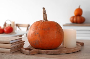 Kabaklı pansiyon, yanan mumlar ve mutfak tezgahında kitaplar.